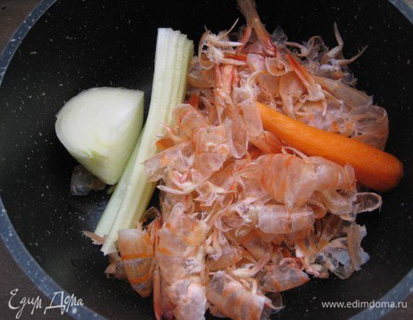 Рыбный бульон: в кастрюлю сложить панцири и головы креветок, полстебля сельдерея, маленькую очищенную морковь, половину небольшой луковицы. Залить 2 л холодной водой, довести до кипения и варить 20 минут. Посолить. 