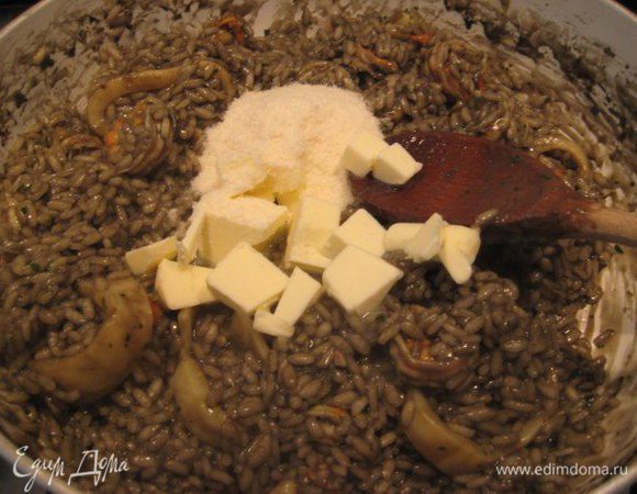 Ризотто снять с огня, положить кубики холодного сливочного масла и тертый пармезан, хорошо перемешать.