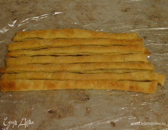 На стол выкладываем пищевую пленку в 3-4 слоя (лучше пленки не жалеть, если слой будет плотный, будет проще скручивать в полено). На пленку в ряд выкладываем охлажденные пластинки. 