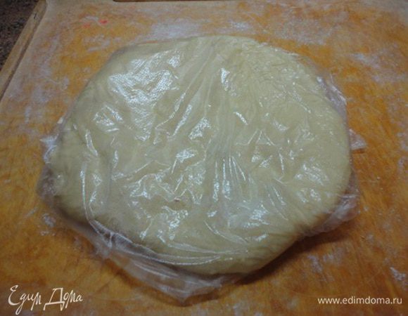 Накрыть тесто пищевой пленкой и поставить на сорок минут в теплое место. Затем обмять его — пару раз собрать бока и вмять в центр колобка. Расплющить его в лепешку диаметром примерно 30 см и положить на ночь в холодильник.