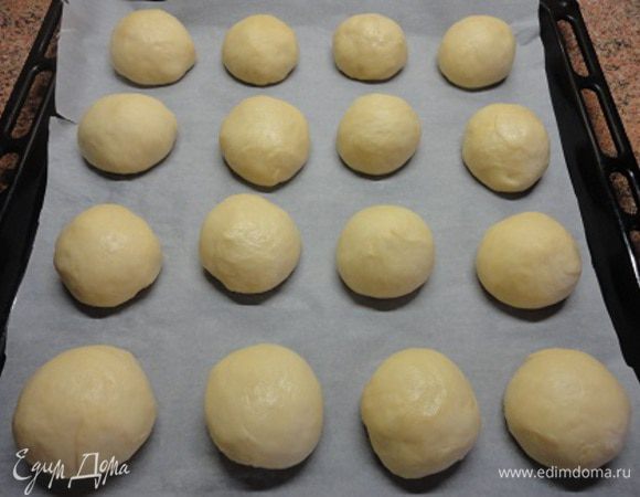 Утром из этой лепешки я стаканом вырезала 16 толстых кружков и скатала ровные колобки, разложила их на застеленный пекарской бумагой противень  и поставила еще на час в теплое место. 