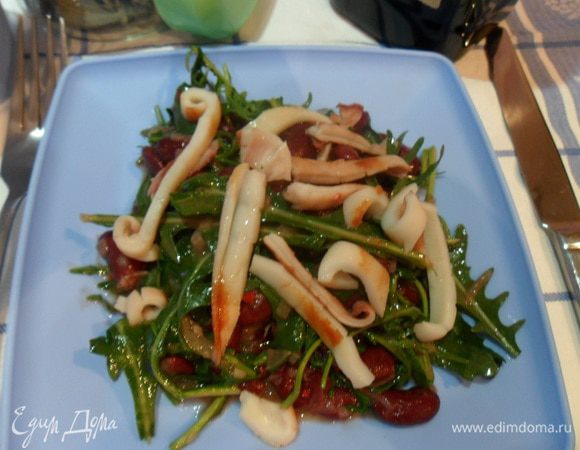 Смешать руколу с фасолью, полить заправкой и перемешать. Выложить на тарелку, сверху выложить нарезанные кальмары. Сразу подавайте. Приятного аппетита!