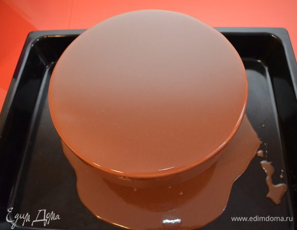 Готовим глазурь: желатин замачиваем в холодной воде, шоколад растапливаем. Глюкозу и воду нагреваем до объединения, добавляем сахар и нагреваем до 103С, снимаем с огня. Добавляем желатин и сгущенку, перемешиваем и вливаем в эту массу растопленный шоколад. Дальше очень важный момент — пробиваем глазурь блендером. Это нужно делать в глубокой чаше. Блендер опускаем в глазурь, чашу немного наклоняем набок, включаем блендер и просто держим его, не поворачивая, не поднимая-опуская. Блендер сам пропустит глазурь через лезвия и вы получите гладкую массу без пузырьков, сито вам также не понадобится. Рабочая температура глазури 35-40С.

Замерзший торт покрываем глазурью, установив его на решетку. Работать с глазурью надо быстро и чётко. Начинаем покрывать от центра и круговыми движениями переходим к бокам. Излишки глазури снимаем одним движением спатулы от себя. Чем быстрее вы будете работать, тем ровнее ляжет глазурь!

 