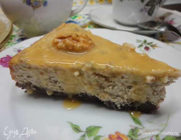 Приготовить карамельный соус. В сотейник с толстым дном положить сахар и нагревать помешивая, пока он не станет золотистого цвета, снять с огня. Сливки  прогреть, не доводя до кипения, и тонкой струйкой вливать к сахару,  постоянно помешивая. Если образовались кусочки леденцов, не переживайте, они растворятся. Теперь эту массу довести до кипения, добавить сливочное масло, хорошо перемешать и варить на медленном огне 5 минут. Охладить. Полить чизкейк, украсить его орехами и убрать в холодильник на 2 часа. У меня он стоял ночь. Когда убрала края разъемной формы, соус красиво разлился по блюду. Вот такой он в разрезе.