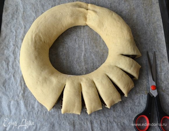 Теперь, с помощью кухонных ножниц, сделать по всей окружности рулета надрезы, не разрезая до конца. Расстояние между сегментами — около 1,5 см.