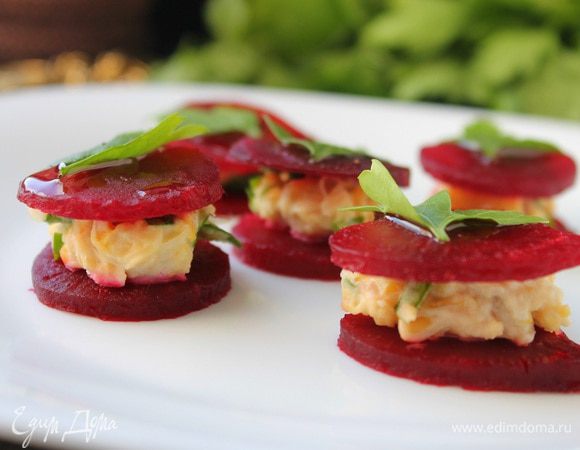 Сервируем блюдо. На кружочек свеклы кладем 0,5 ч. л. нута с зеленью и чесноком, сверху накрываем вторым кружочком свеклы. Украшаем листьями петрушки. Каждую башенку сбрызнуть оливковым маслом смешанным с бальзамическим уксусом. Подаем сразу же. Приятного аппетита!