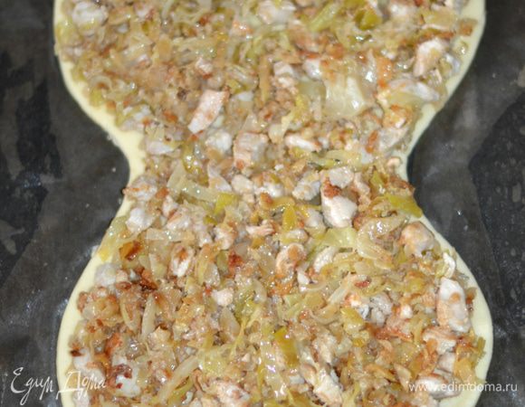Выложить заготовку на противень, застеленный пекарской бумагой. Я смазала бумагу растительным маслом. Выложить начинку. Для начинки мелко порубить куриное филе, обжарить до слегка золотистого цвета на растительном масле. Добавить мелко пошинкованную молодую капусту. Посолить, поперчить, обжарить до готовности.