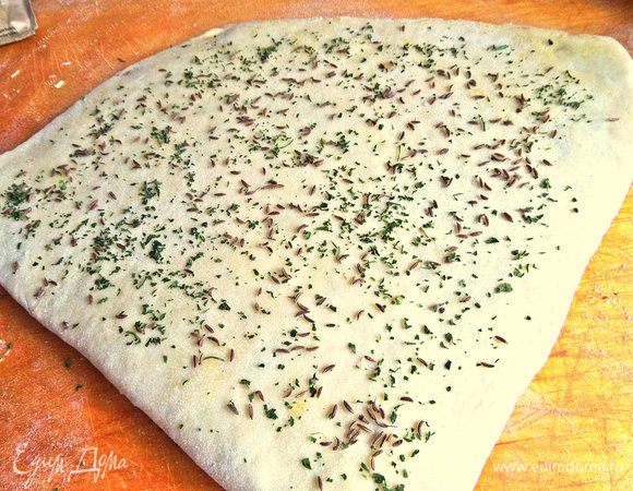 Тут я решила посыпать петрушкой и тмином,но можно просто сделать посыпку только сверху. Снова складываем пополам,раскатываем.