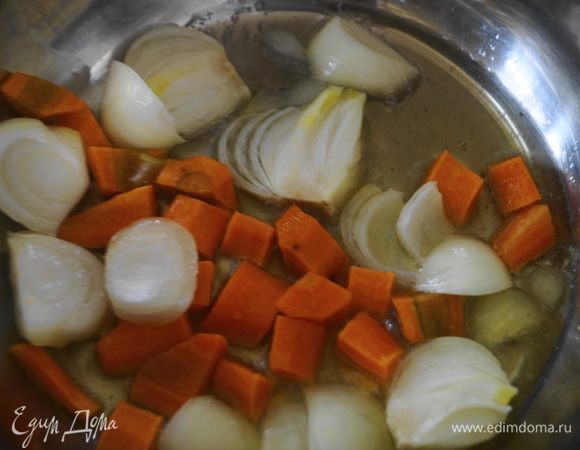 Лук и морковь очистить, промыть и крупно нарезать. В кастрюле разогреть оливковое масло и обжарить на нем овощи до мягкости.