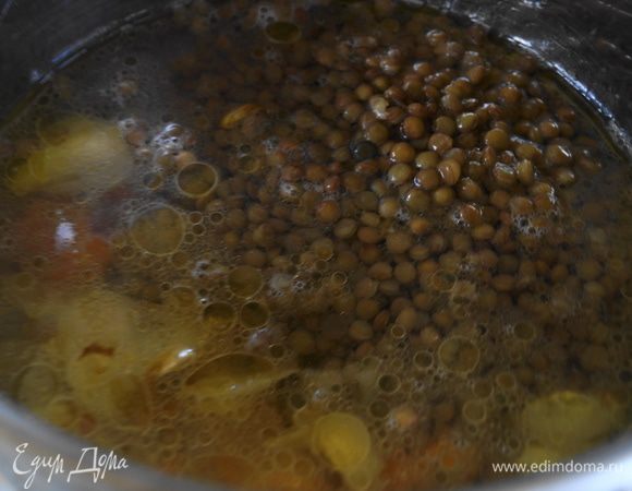 Обжаренные овощи залить бульоном, лучше взять овощной бульон. Добавить чечевицу и варить суп 20 минут, до готовности самой чечевицы.