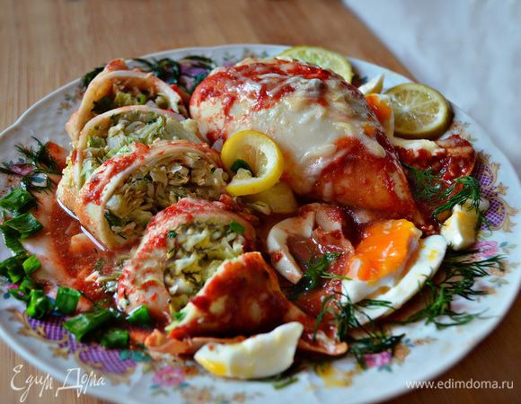 Нарезать тушки кальмаров кусочками толщиной 2 см, выложить на тарелку и полить томатным соусом. По желанию блюдо можно украсить лимоном и зеленью. Приятного вам аппетита!