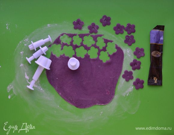 Мастику разделить на несколько частей. В каждую часть добавить разный краситель. С помощью плунжеров вырезать заготовки для цветов,