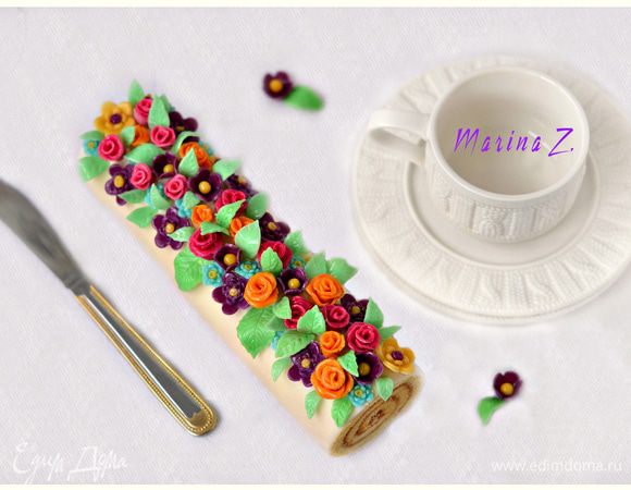 На каждый цветок с обратной стороны наносим немного крема, чтобы он держался на рулете. 