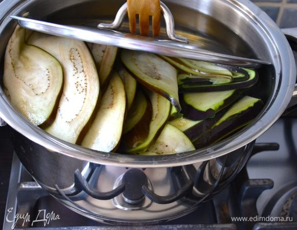 Выложите их в два захода в кастрюлю с кипящей подсоленной водой. Проварите минут 5-7, пока баклажаны не станут мягкими.  