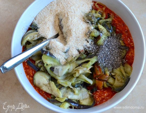 Выложите томатный соус в миску, добавьте баклажаны, панировочные сухари и семена чия (по желанию можно заменить на семена льна). Перемешайте.  