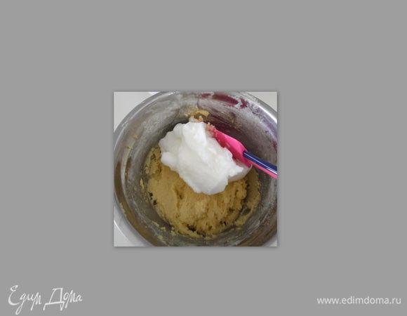 Добавлять белки по частям в желтковую массу и перемешивать.