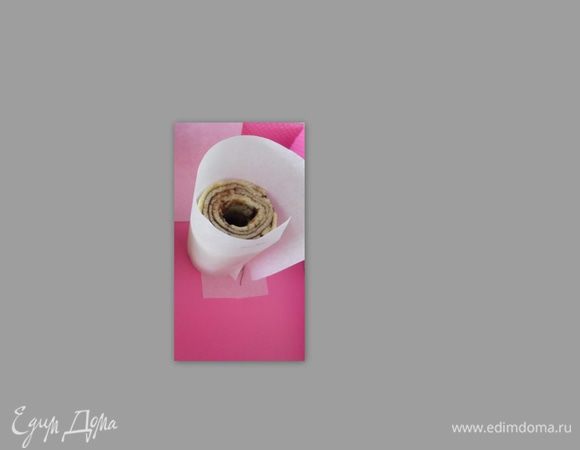 Вырезать полоску из бумаги для выпечки, полоску соответствующую диаметру и высоте рулета, возьмите высоту больше на 1-2 см.