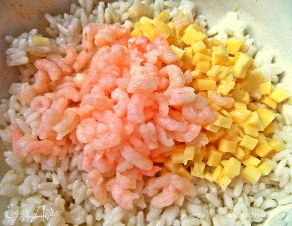 В рис высыпаем сыр, креветки.