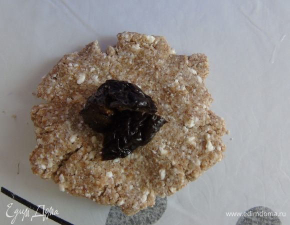 Разделить тесто на шарики (у меня выходит 9 шт), размять в лепешку, посередине положить чернослив, защипнуть и чуть приплюснуть. 