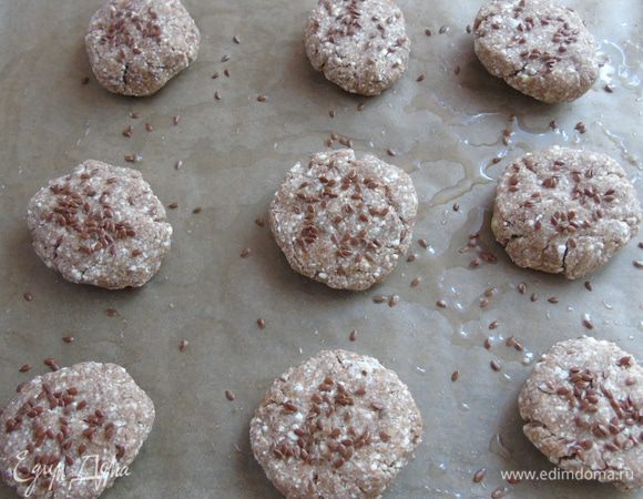 Выложить на противень, застеленный пергаментом и смазанный растительным маслом, посыпать льняными семечками. Выпекать 25-30 минут в разогретой до 180 С духовке. 