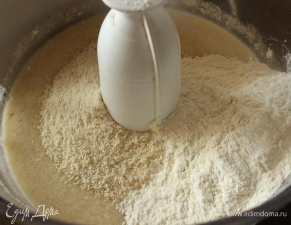 Засыпаем пшеничную и миндальную муку (можно смолотый миндаль, либо на крайний случай простую муку +20 г). 
Тщательно вымешиваем тесто. Важно добиться плотной однородной консистенции.
Выливаем в форму. Насчет формы... Тоже важно, так как время выпечки будет у всех разное. Андрей брал застеленную пергаментом длинную около 30 см со стенками и дном около 8 см. И выпекал хлеб 20 минут. 
Я взяла силиконовую форму для хлеба размером 20,5х11,5см высотой 6 см. (важно, чтобы она была в металлическом обрамлении, так как тесто плотное и деформирует ее). Или же делайте импровизированный каркас из подручных материалов, я подставляю к бокам формы что-нибудь подходящее (небольшие металлические противни и т.д.). Тесто практически не растет при выпечке, поэтому форму можно заполнять почти до краев. Силикон не смазываем, другие материалы выстилаем бумагой, либо слегка смазываем маслом и присыпаем мукой.
