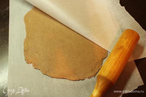 По истечении времени разогреваем духовку до 180 градусов. Раскатываем тесто между двумя листами пергамента в очень тонкий пласт и отправляем его в духовку на 15 минут.