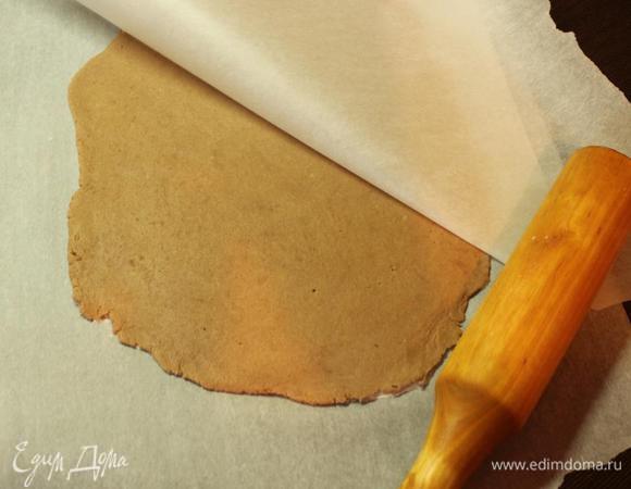 По истечении времени разогреваем духовку до 180 градусов. 
Раскатываем тесто между двумя листами пергамента в очень тонкий пласт и отправляем его в духовку на 15 минут. 
