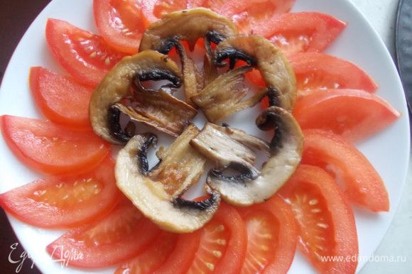 Режем помидор на полудольки и выкладываем красиво по краю тарелки. В серединку слайсы грибочка.
