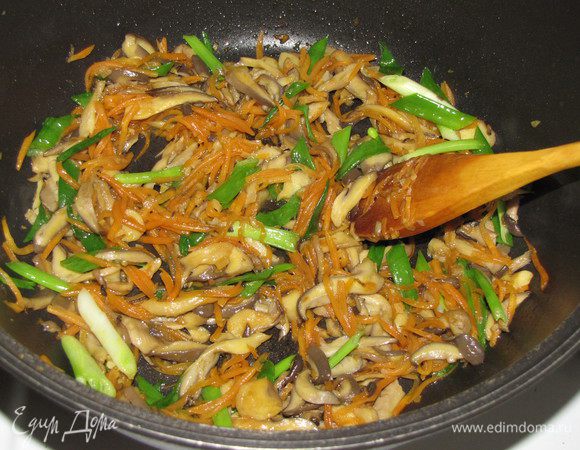 Влить соевый соевый соус и рисовый уксус, жарить еще 1 минуту. Добавить зеленый лук и кунжутное масло. Перемешать и снять вок с огня.