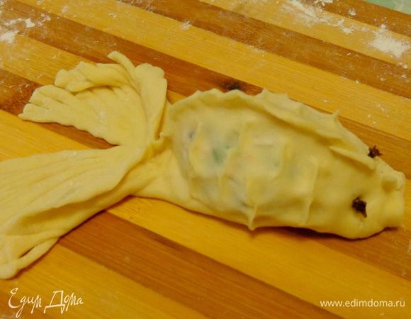 Оформить рот и глазки с помощью гвоздичек. По бокам защипнуть тесто, имитируя чешую. На хвосте сделать мелкие надрезы.