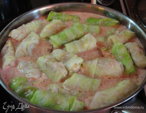 В сотейнике или кастрюле с толстым дном довожу до кипения свежие, натертые помидоры, добавляю сметану, при необходимости немного горячей воды, смолю, перчу и выкладываю голубцы. В центр те, что в сырокопченой грудинке, а по краям и сверху остальные. Еще пару лавровых листиков. Все довести до кипения и варить на медленном огне 20-30 минут. 