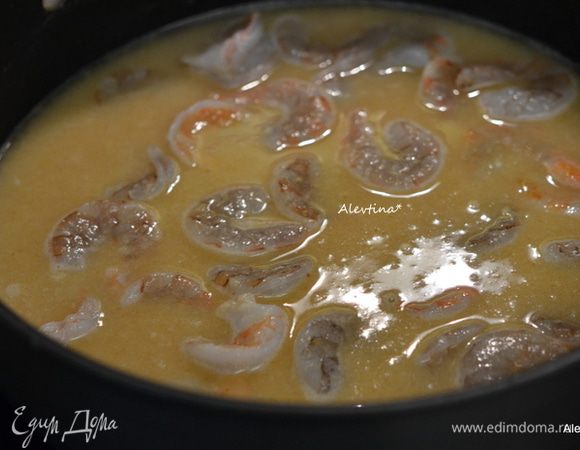 Добавим куриный бульон, перемешаем, затем очищенные креветки. Готовим, помешивая, 10 мин.