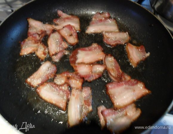 Бекон обжарить на сковороде без масла до золотистого цвета, а точнее, чтобы он стал хрустящим. Вынуть на бумажную салфетку, чтоб убрать лишний жир.