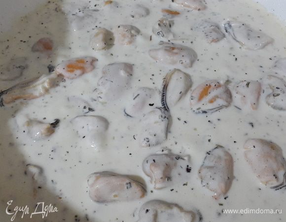 Залить мидии сливками, посолить, поперчить, добавить сушеный базилик, перемешать и тушить 3-5 минут.