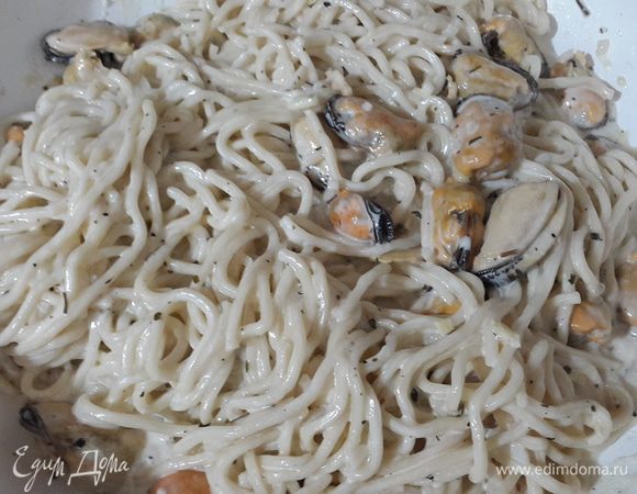 Лапшу откинуть на дуршлаг и соединить с соусом. Аккуратно перемешать и тушить до загустения сливок.