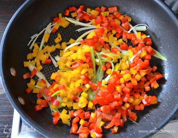 Через минуту добавить в сковороду нарезанный болгарский перец. 