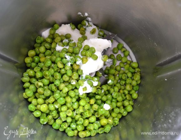 Крем из горошка удобнее всего приготовить в высоком стакане, измельчив всё погружным блендером, но у меня он вышел из строя. Поэтому, кладём горошек (зубчик чеснока предварительно удалить!) и греческий йогурт в стационарный блендер, добавляем листики мяты и взбиваем всё до состояния пюре.