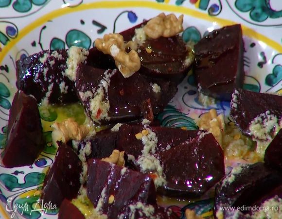 Свеклу полить половиной чесночной заправки, посыпать измельченным руками пеперончино, слегка сбрызнуть оливковым маслом, посолить и украсить поломанными руками грецкими орехами.