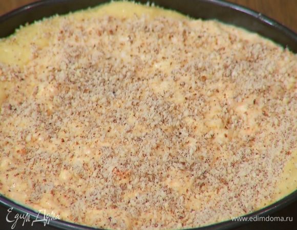 Вынуть из духовки подпеченный корж, выложить на него начинку и присыпать оставшимся измельченным миндалем.