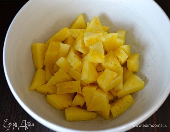 Ананас очистить и нарезать кусочками. Выложить в салатницу.