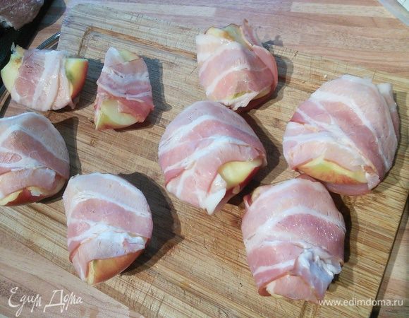 Яблоки плотные разрежем на 4 части и обернём каждую в полоску бекона. 