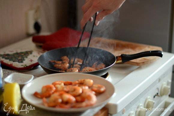 Креветки очищаем от панциря, оставляя хвостик. Посыпаем солью и черным перцем (по вкусу) и обжариваем на оливковом масле примерно по 1-2 минуты с каждой стороны.