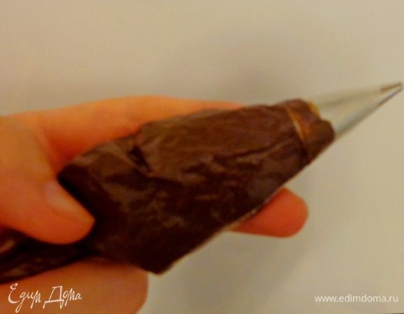 Тем временем сделать "краску" для росписи: какао смешать с кипятком и добавить половину желтка. Консистенция краски должна быть как у заварного крема. Переложить краску в кулинарный кулек.