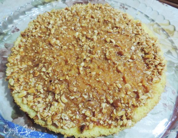 Каждый пласт пропитываем карамелью и посыпаем арахисом. А можно карамель смешать с арахисом и этой массой промазать коржи. Немного ждем, пока карамель впитается.