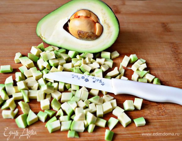 Авокадо разрезать пополам, вынуть косточку, удалить с авокадо шкурку, мякоть нарезать кубиками, сбрызнуть лимонным соком.