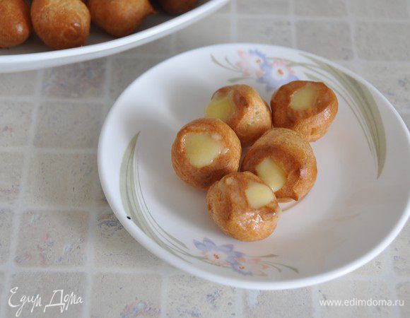 Все составные части наших апельсиновых пирожных готовы: апельсиновый бисквит, крем "дипломат", шу, лимонный курд. 
Начнем сборку. Маленькие пирожные шу начинить лимонным курдом с помощью кондитерского мешка с тонкой насадкой. 

