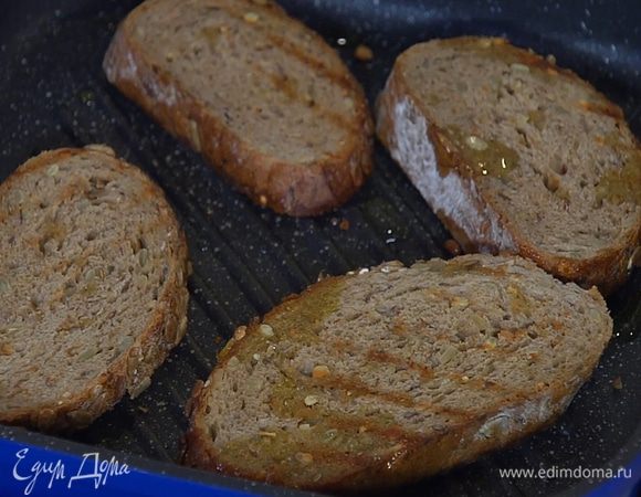 Разогреть в сковороде-гриль оливковое масло и обжарить хлеб с двух сторон.