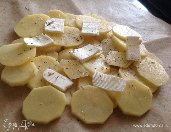 Отступив от края 5 см, выложить слоями картошку, соль, перец, розмарин и сливочное масло.