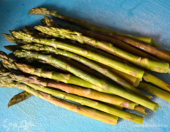 Перед тем как приступить к приготовлению спаржи, следует ее очистить. После этого надо обрезать или отломить примерно два сантиметра от конца стебля. Духовку включить разогреваться на 180 °C.