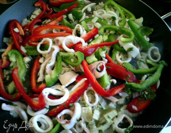 Лук, чеснок, петрушку мелко нарезать, перец нарезать соломкой, все добавить к кальмарам. Обжарить 5 минут. 